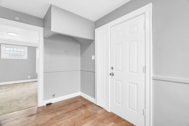 clothes washing area featuring light hardwood / wood-style floors