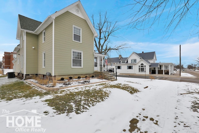 snow covered property featuring central air condition unit