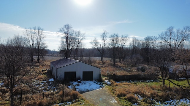 view of outdoor structure featuring a garage and a rural view