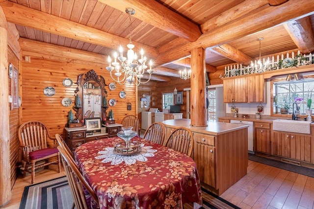 dining space featuring sink, a notable chandelier, independent washer and dryer, beam ceiling, and light hardwood / wood-style flooring