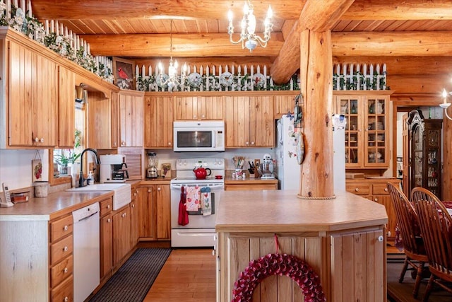 kitchen featuring decorative light fixtures, beamed ceiling, a center island, a notable chandelier, and white appliances