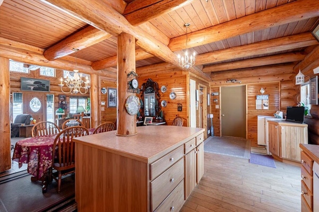 kitchen with pendant lighting, light hardwood / wood-style floors, a kitchen island, a chandelier, and light brown cabinets