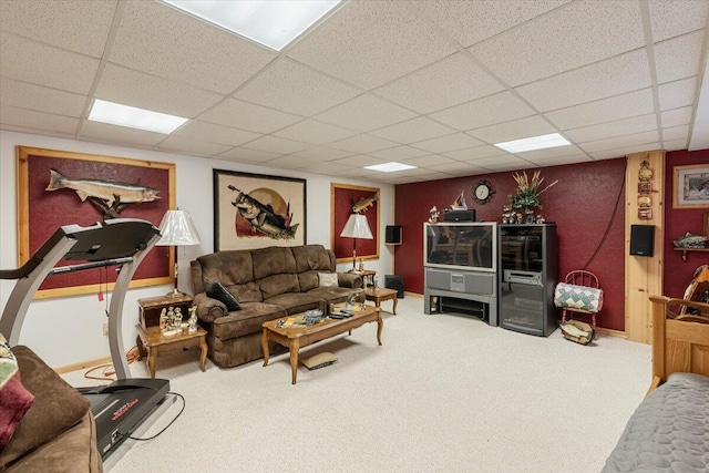 carpeted living room featuring a drop ceiling