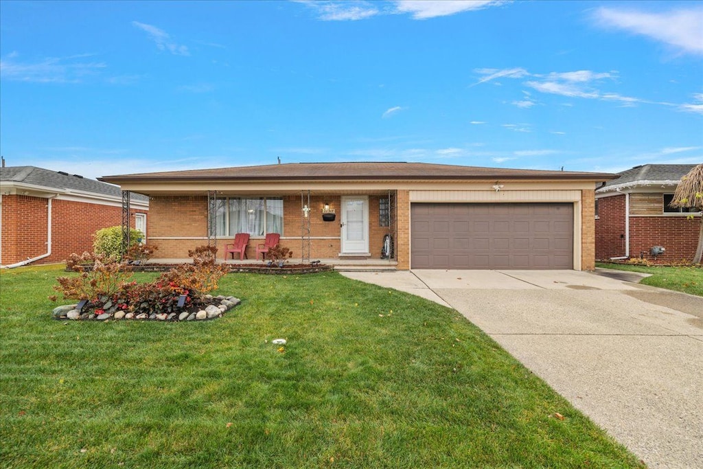 ranch-style house featuring a garage and a front lawn