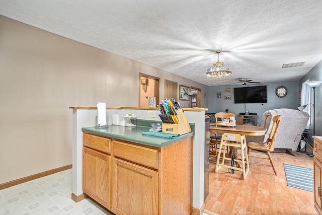 kitchen featuring ceiling fan, a textured ceiling, and light hardwood / wood-style flooring