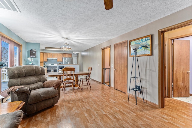 living room featuring a textured ceiling and light wood-type flooring