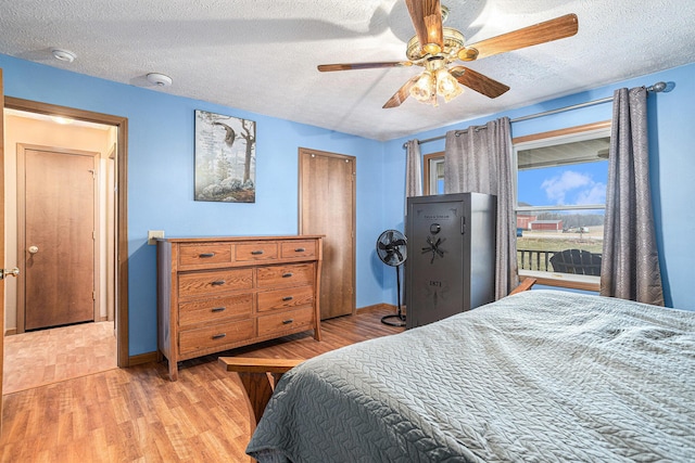 bedroom featuring ceiling fan, a textured ceiling, and light wood-type flooring