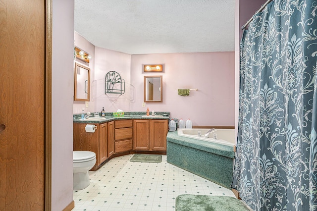 bathroom with vanity, toilet, and a textured ceiling