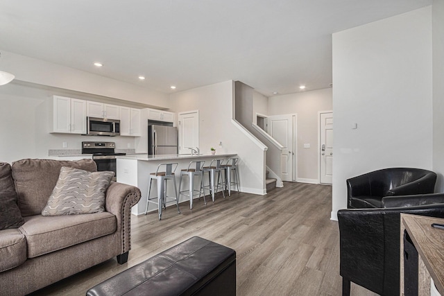 living room featuring sink and light hardwood / wood-style floors