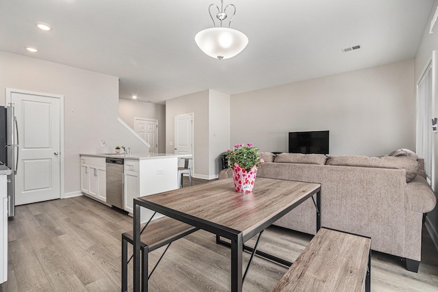 dining area featuring sink and light hardwood / wood-style floors