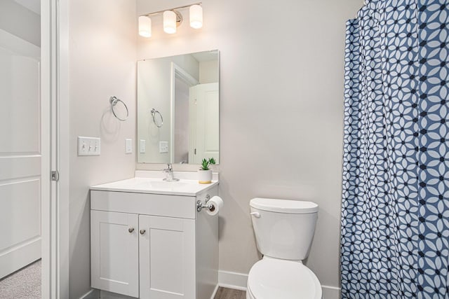 bathroom featuring vanity, curtained shower, and toilet