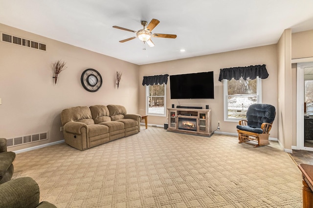 carpeted living room featuring a wealth of natural light and ceiling fan