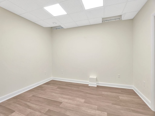 spare room with light hardwood / wood-style floors and a drop ceiling