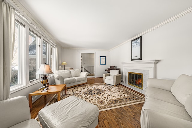 living room with hardwood / wood-style floors, crown molding, and a premium fireplace