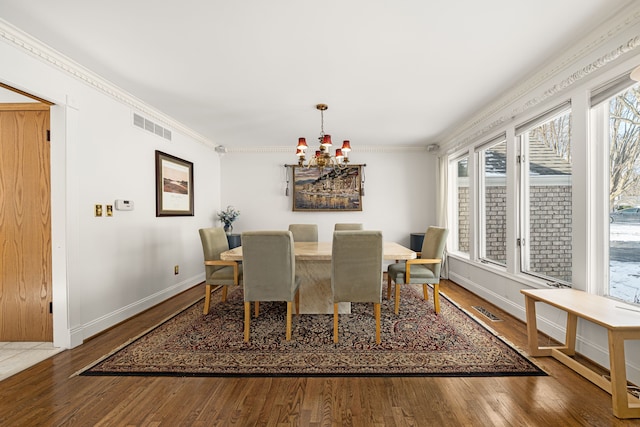 dining room with ornamental molding, a chandelier, and wood-type flooring