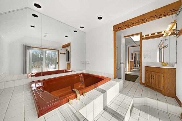 bathroom with tile patterned flooring, vanity, a relaxing tiled tub, and lofted ceiling