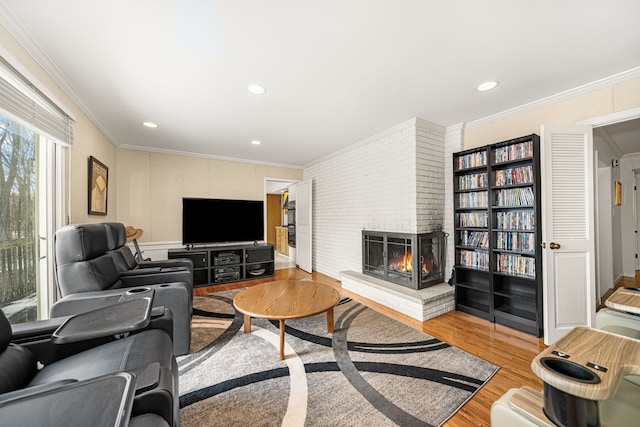 living room with light hardwood / wood-style flooring, crown molding, and a brick fireplace