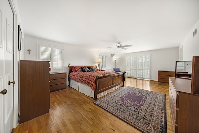 bedroom featuring hardwood / wood-style floors, multiple windows, and ceiling fan