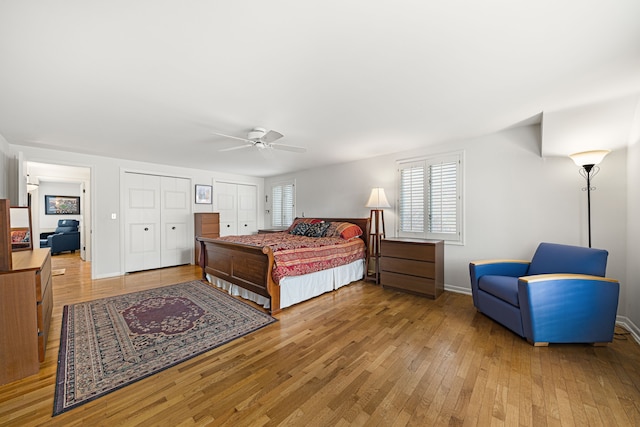 bedroom with multiple closets, light hardwood / wood-style floors, and multiple windows