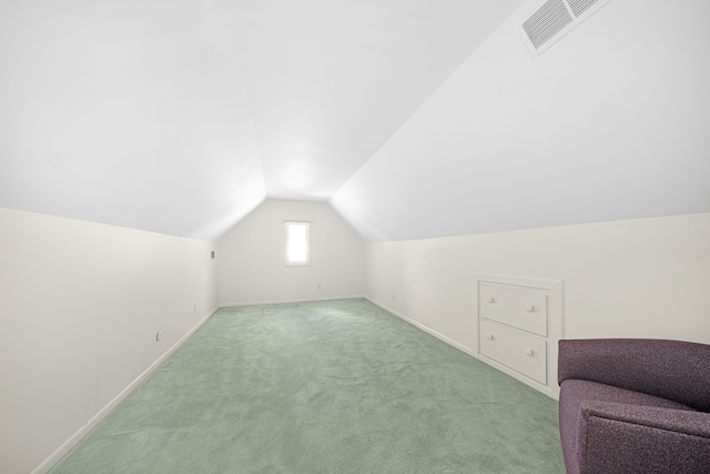 additional living space featuring light carpet and vaulted ceiling