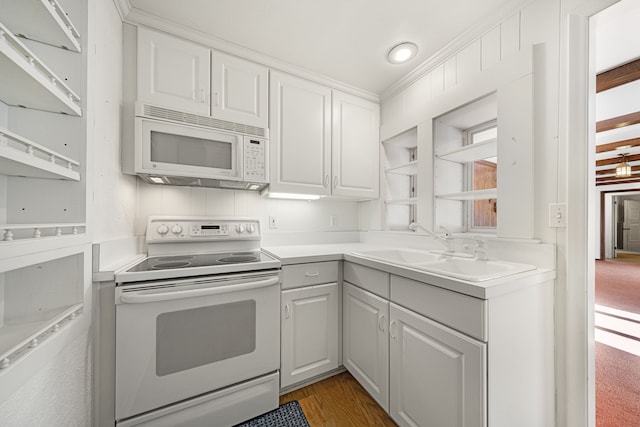 kitchen with sink, white appliances, white cabinetry, and wood-type flooring