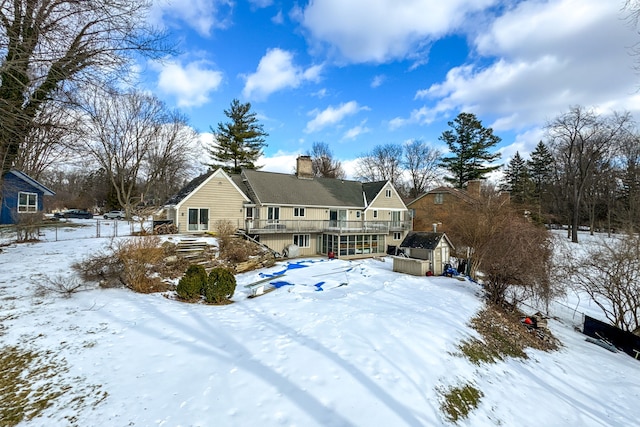 snow covered back of property with a storage shed