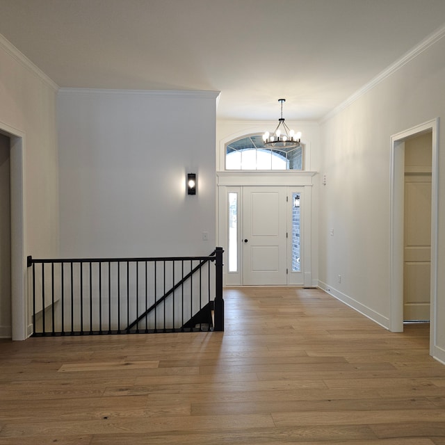 foyer entrance featuring a notable chandelier, light hardwood / wood-style floors, and crown molding