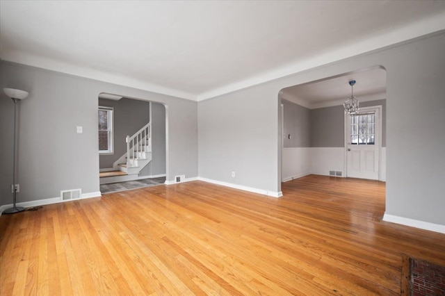 unfurnished room featuring hardwood / wood-style flooring and a notable chandelier