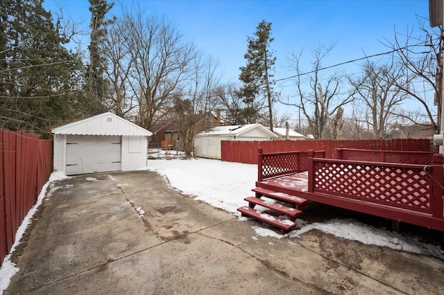 yard layered in snow featuring a wooden deck, a garage, and an outdoor structure