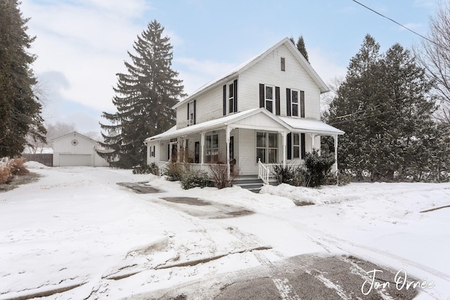 view of front of house featuring an outbuilding, a porch, and a garage