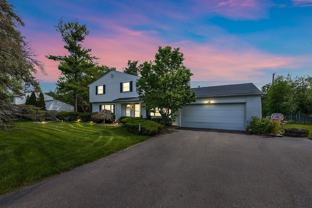 view of front of home featuring a garage and a lawn