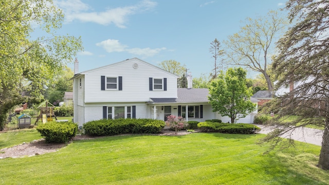 view of front of property with a playground and a front lawn