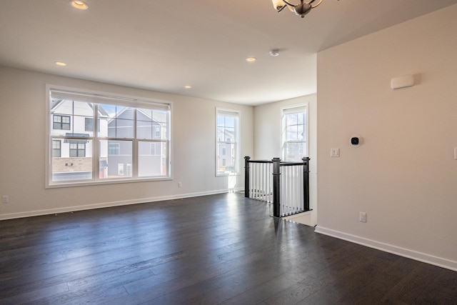 spare room with dark wood-style floors, recessed lighting, and baseboards