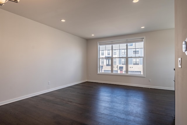 empty room with dark wood-type flooring, recessed lighting, and baseboards