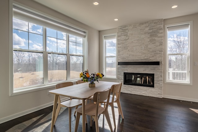 dining room featuring recessed lighting, dark wood-type flooring, a fireplace, visible vents, and baseboards