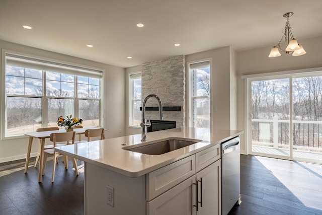 kitchen featuring plenty of natural light, dishwasher, dark wood-style floors, light countertops, and a sink