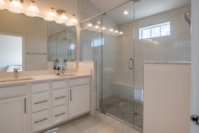 bathroom featuring marble finish floor, double vanity, a sink, and a shower stall