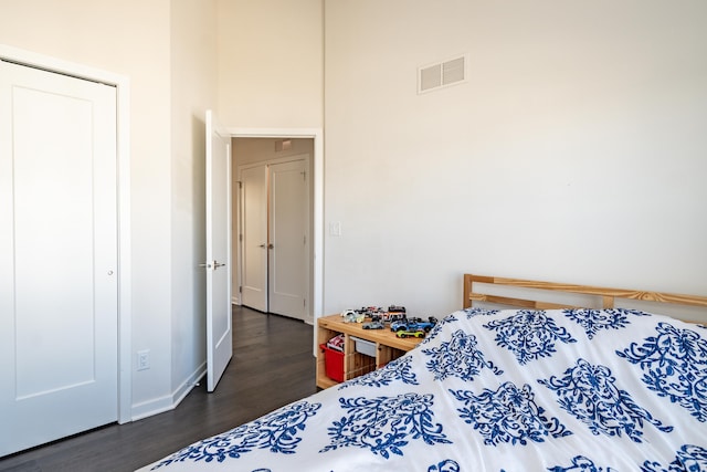 bedroom with visible vents, dark wood finished floors, and baseboards