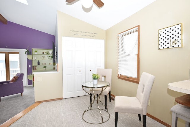 dining space featuring ceiling fan, light colored carpet, and lofted ceiling