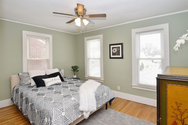 bedroom with crown molding, ceiling fan, and wood-type flooring