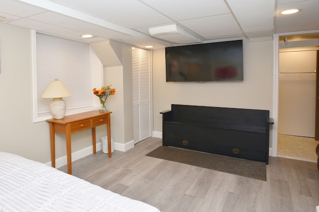 bedroom with light hardwood / wood-style floors and a paneled ceiling