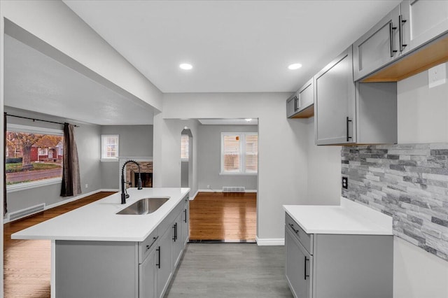 kitchen featuring sink, gray cabinetry, and light wood-type flooring