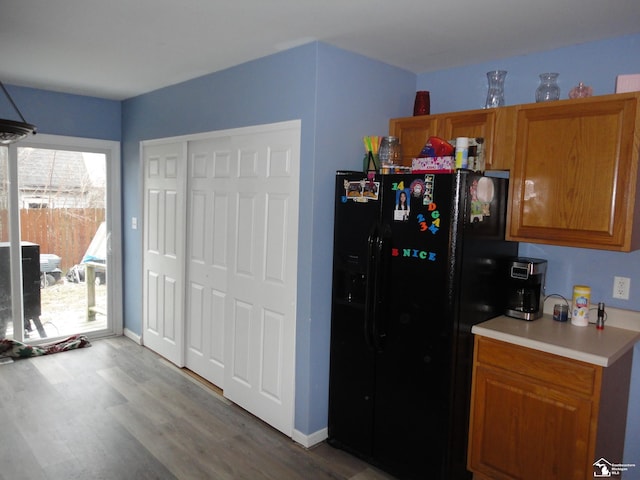 kitchen with wood-type flooring and black fridge