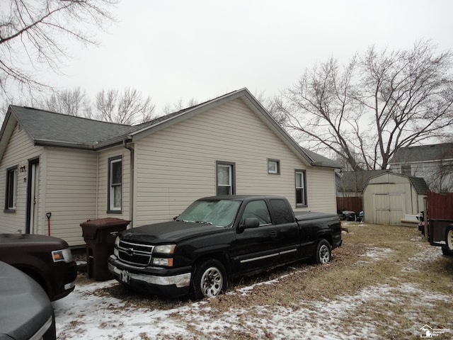 snow covered property featuring a storage shed