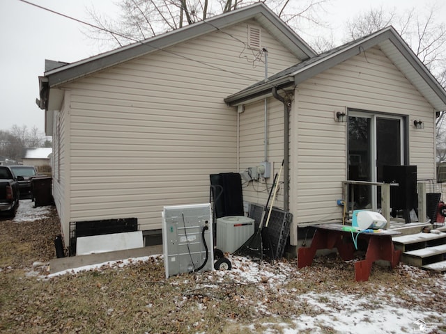 snow covered house with cooling unit