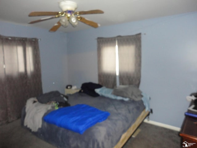 carpeted bedroom featuring multiple windows and ceiling fan