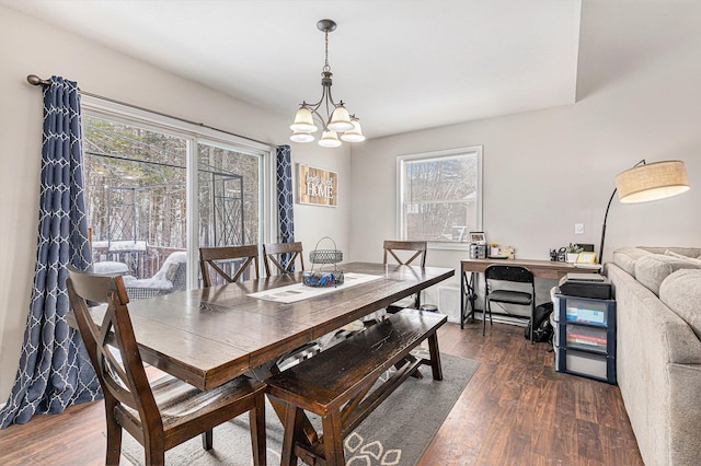 dining area with dark wood-type flooring and a chandelier