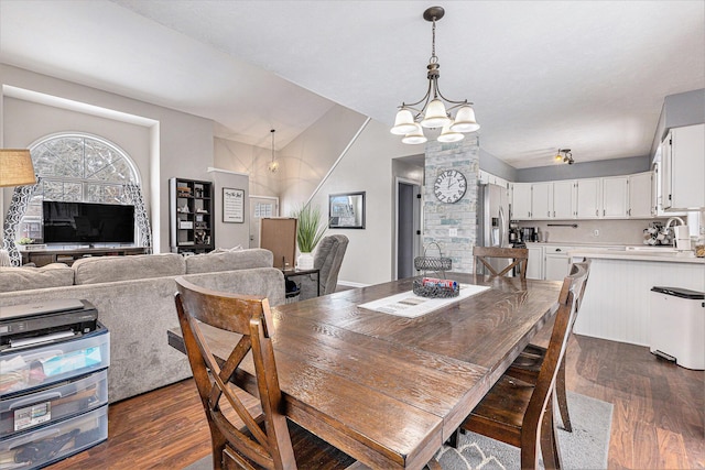 dining area with dark wood-type flooring and an inviting chandelier