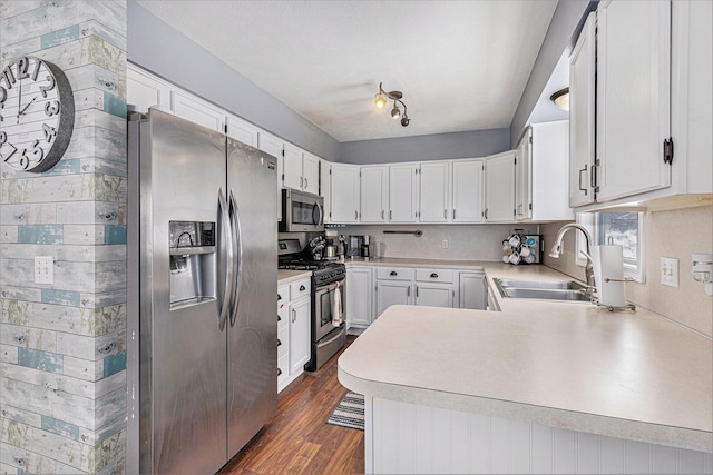 kitchen featuring white cabinetry, appliances with stainless steel finishes, kitchen peninsula, and sink