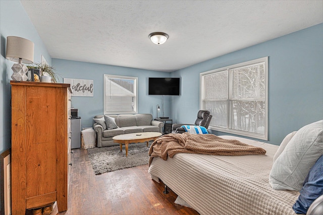 bedroom with wood-type flooring and a textured ceiling